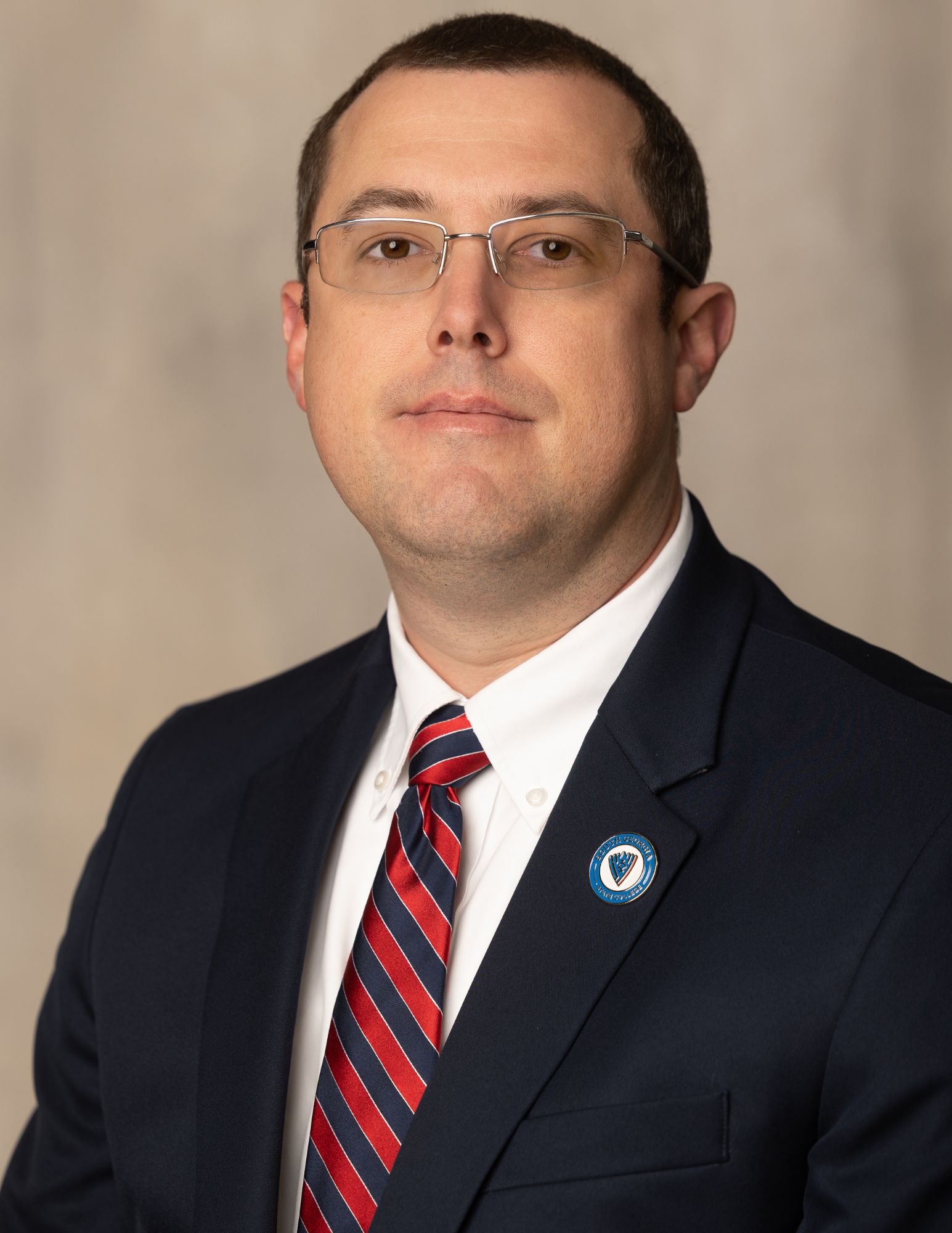 a headshot picture of a man in a suit and tie